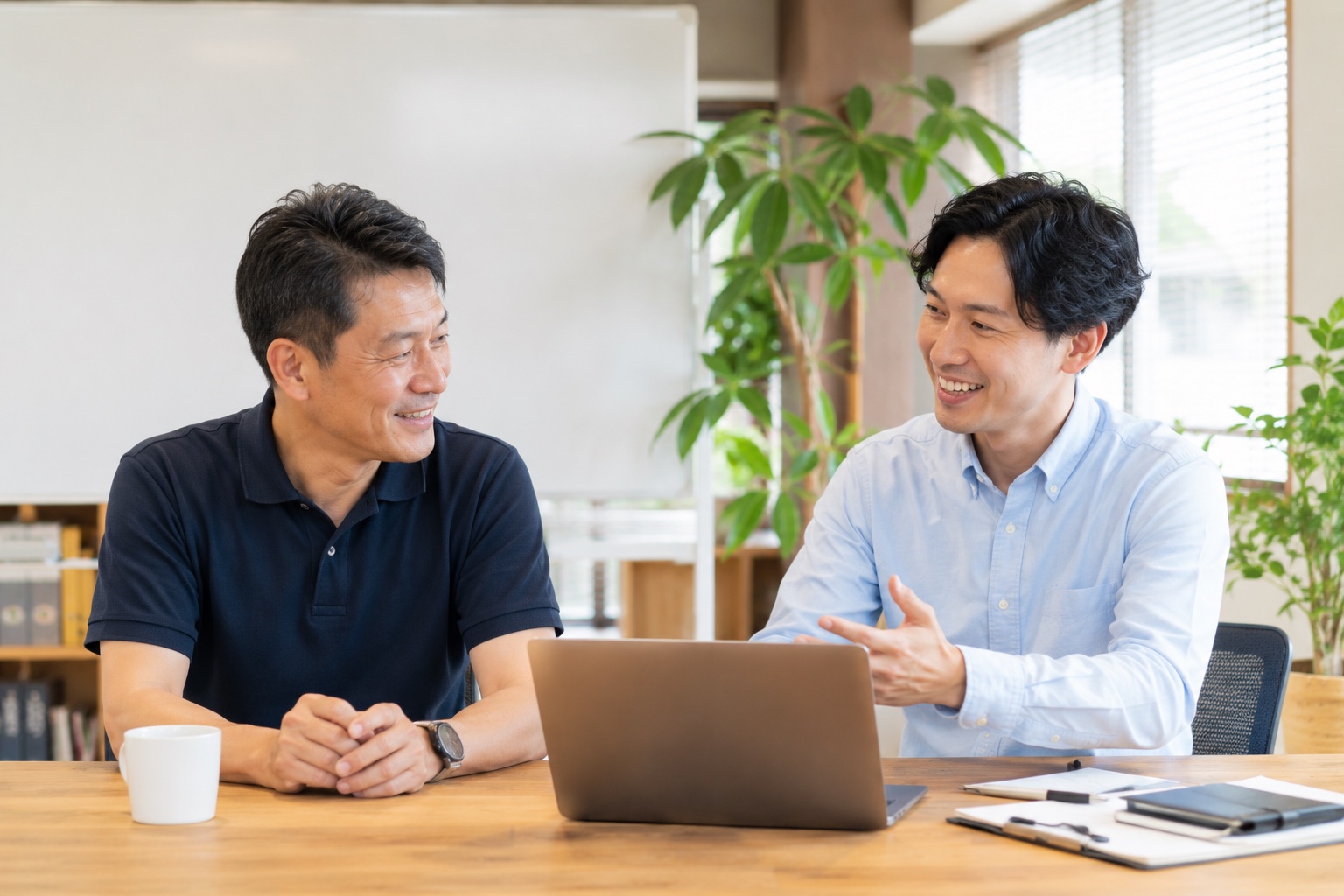 経営者とコンサルが笑顔で打ち合わせをしている様子